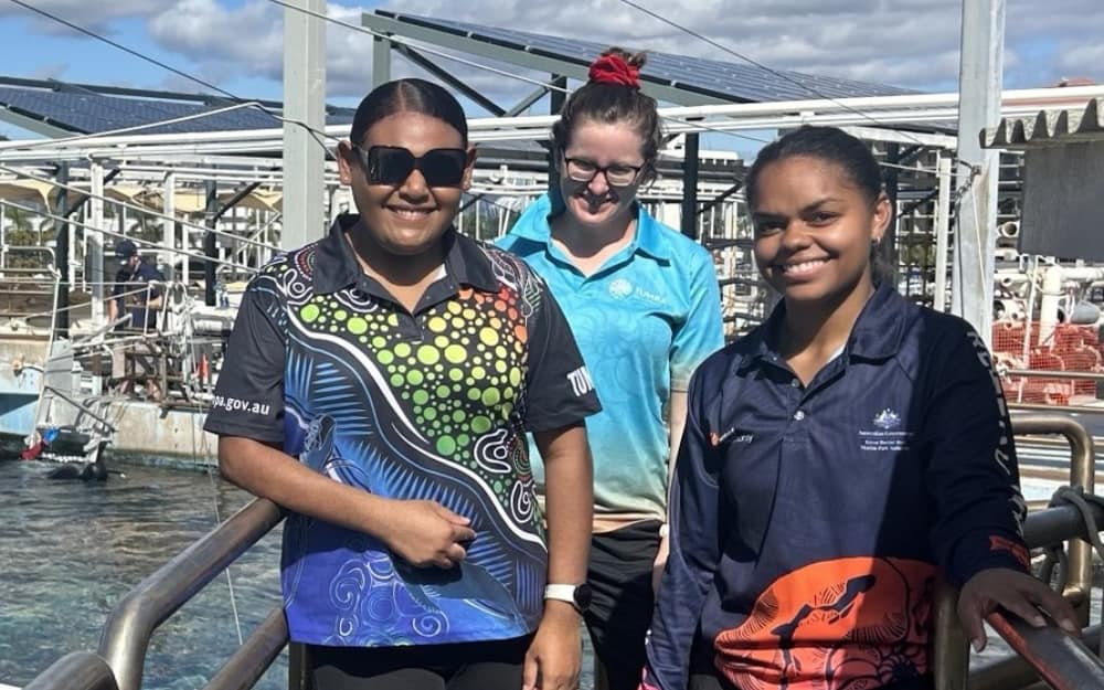 Three women standing above pool of water