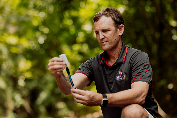 Matthew Radburnd conducting a water testing activity outdoors