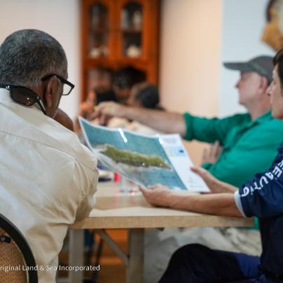 A group of people sitting at a table looking at a map