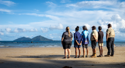 Six people standing on the beach looking out into the horizon. (C): Commonwealth of Australia: Reef Authority