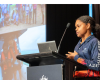 Woman in front of a podium delivers a presentation