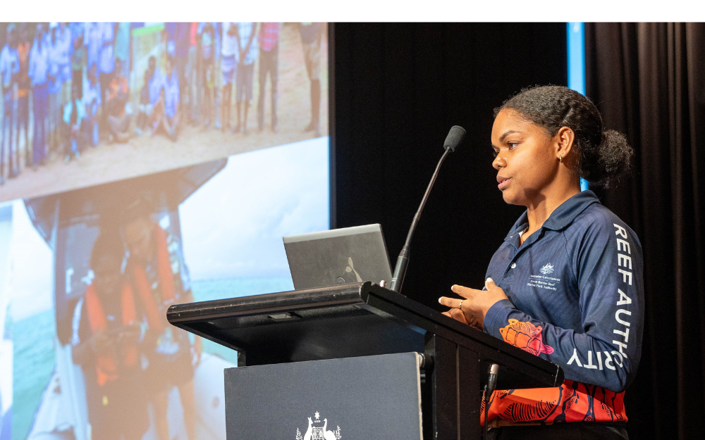 Woman in front of a podium delivers a presentation