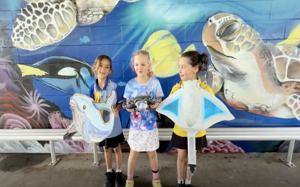 Three kids holding art