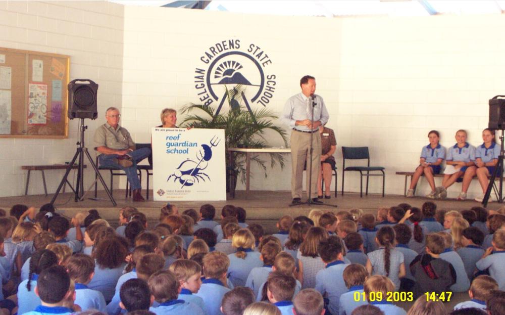 A man speaks at podium in front of students