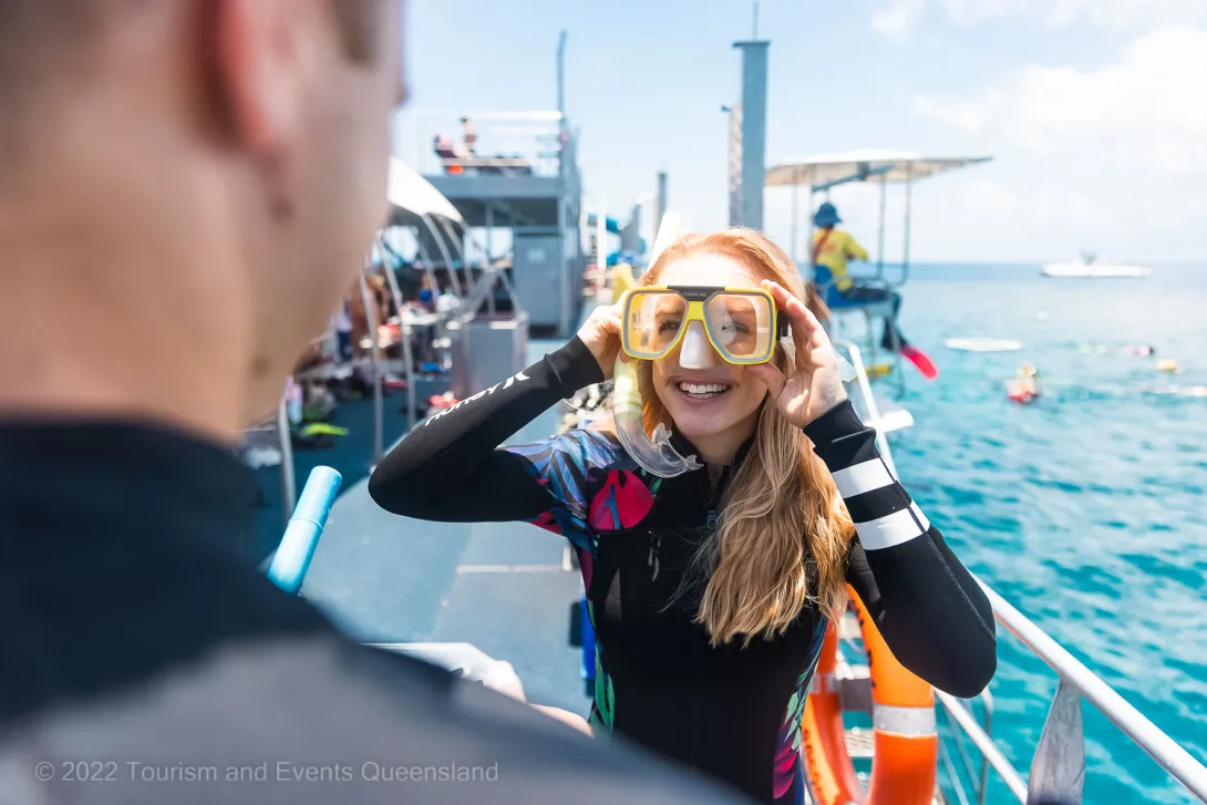 Person putting on a snorkel on a commercial operator  – Australia - © Tourism and Events Queensland